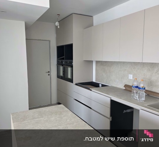 מטבח מודרני בעיצוב אינטגרלי עם אי וחיפוי שיש תואם